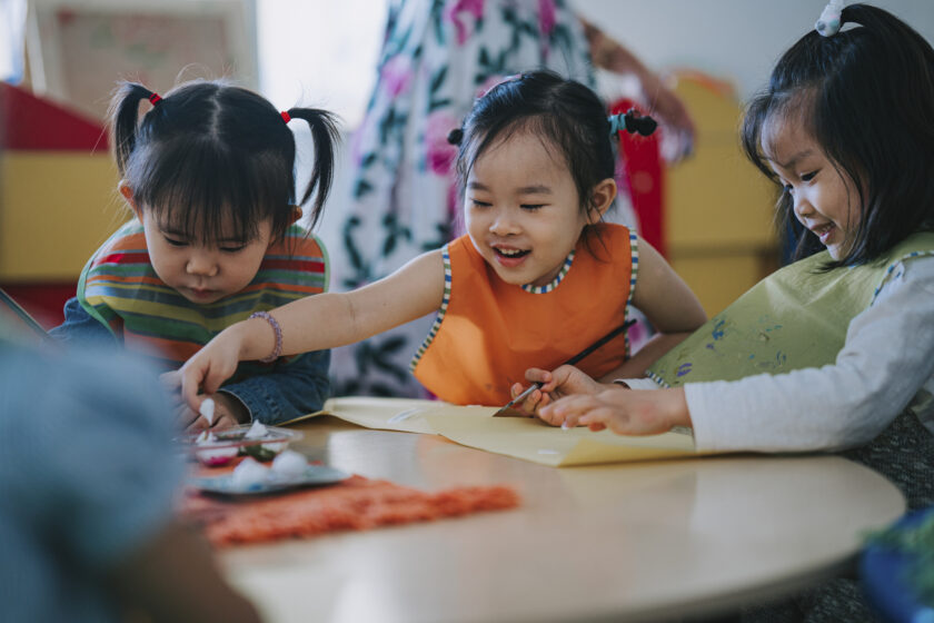 A group of young children playing at a table.